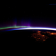 A March 2012 view of night lights in Ireland and the UK from the International Space Station, as the Aurora Borealis lights the space around earth green and purple.